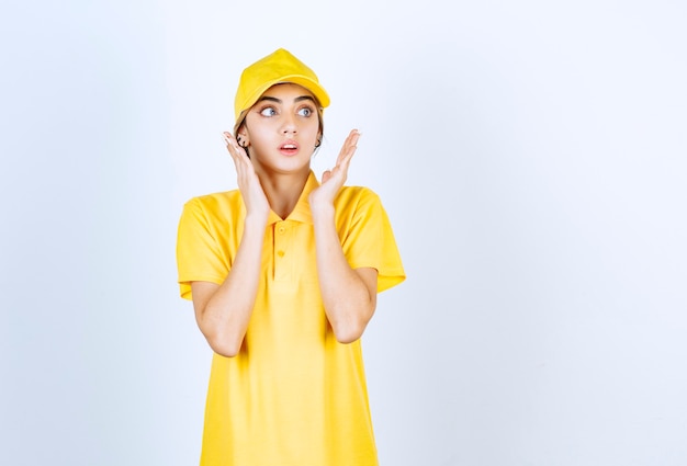 Livreuse en uniforme jaune debout et posant.