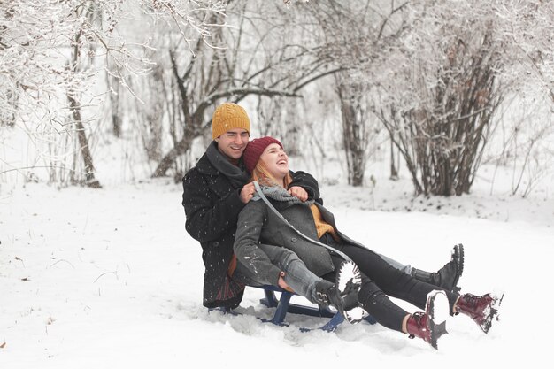 Long coup de couple assis sur un traîneau dans la neige