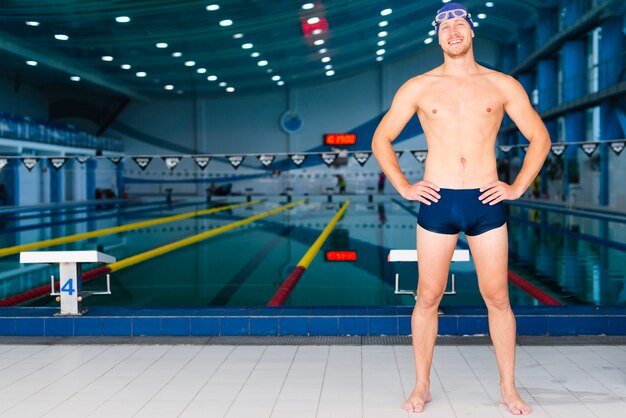 Long-homme posant devant la piscine