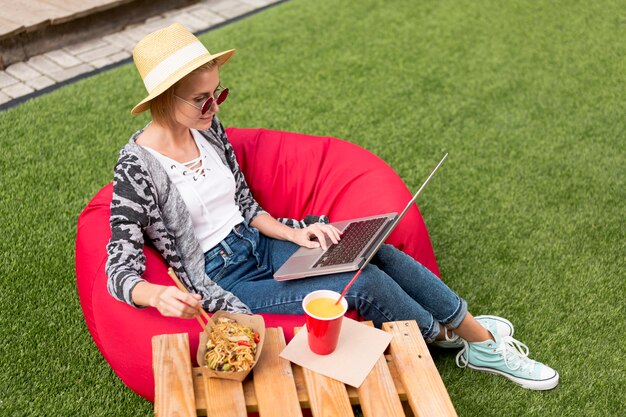 Long plan d'une femme regardant un ordinateur portable