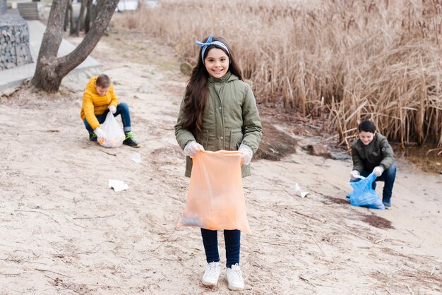 Long shot sur les enfants avec des sacs en plastique