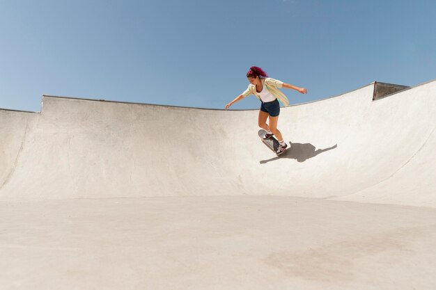 Long shot femme avec planche à roulettes à l'extérieur