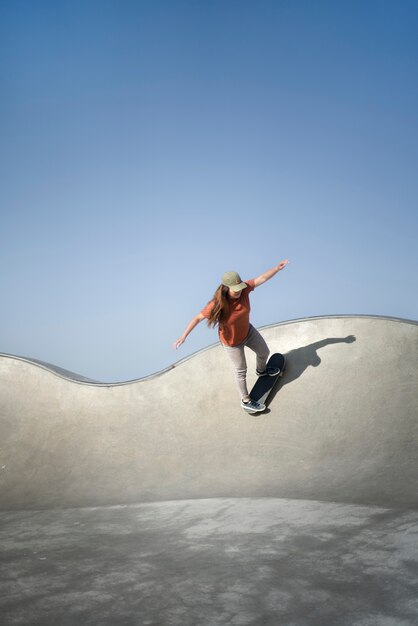 Long shot femme sur skateboard