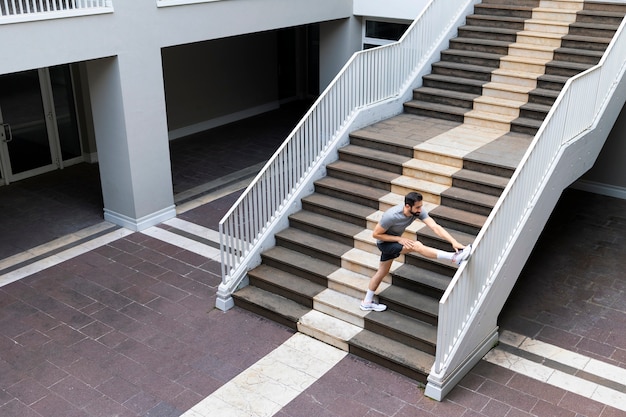 Long shot homme qui s'étend dans les escaliers