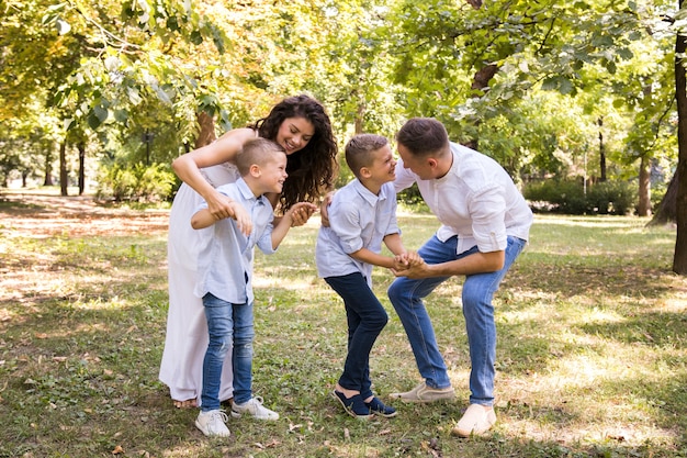 Long shot parents jouant avec leurs garçons