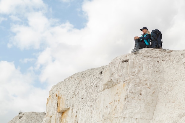 Photo gratuite long shot voyageur assis sur une montagne