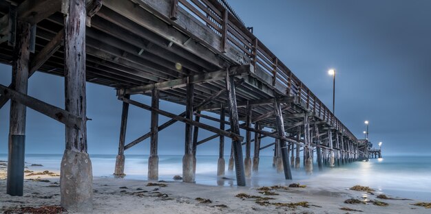 Une longue exposition d'une jetée en bois dans la mer en Californie le soir