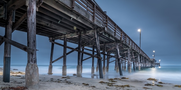 Une longue exposition d'une jetée en bois dans la mer en Californie le soir