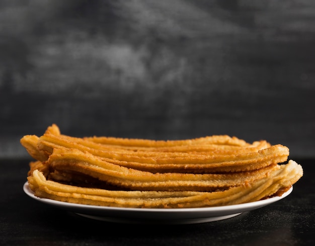 Longue vue d'une assiette blanche remplie de churros