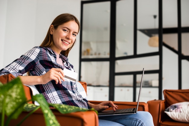 Longue vue de femme assise et regardant la caméra