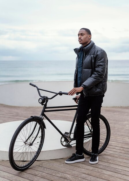 Longue vue de l'homme avec son vélo