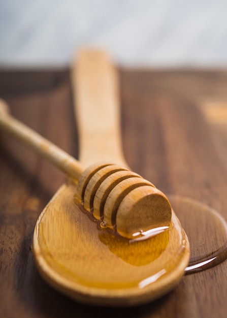 Louche de miel sur une cuillère en bois avec du miel