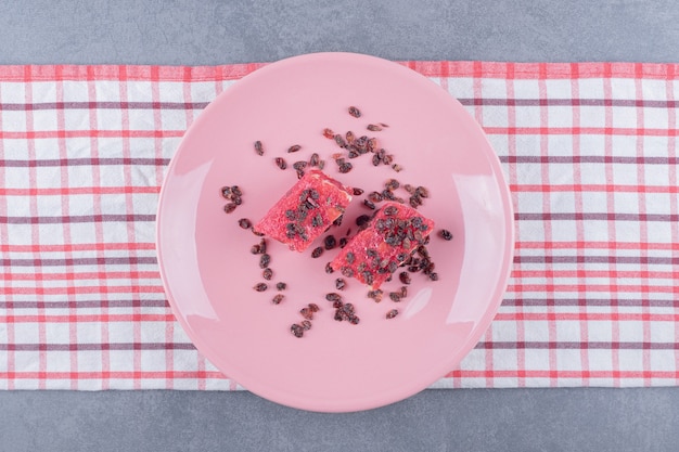 Loukoum rahat lokum aux pistaches et raisins secs sur plaque rose. vue de dessus.