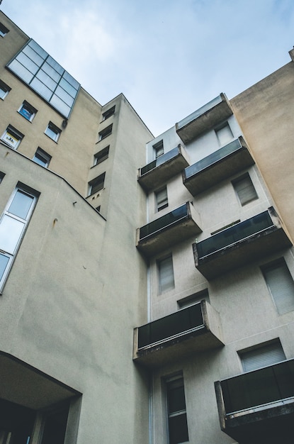 Photo gratuite low angle shot vertical d'un bâtiment architectural abstrait marron avec balcons et fenêtres