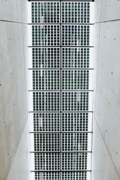 Photo gratuite low angle shot vertical du plafond métallique dans un couloir en béton blanc