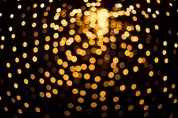 Lumières dorées floues sur fond noir motif festif pour votre conception