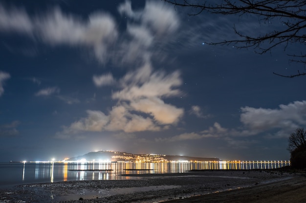 Lumières de la ville et ciel nocturne de la plage de Sandsfoot dans le Dorset, Royaume-Uni