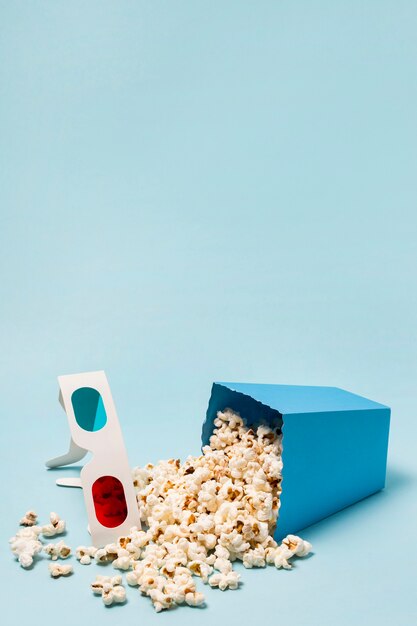 Lunettes 3D avec des pop-corn renversés sur fond bleu