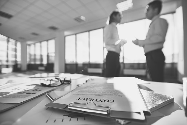 Lunettes sur un bureau de bureau avec les employés de parler