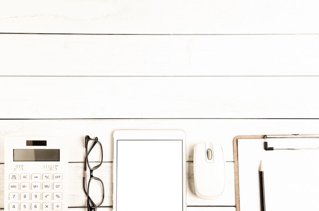 Lunettes, calculatrice et tablette sur blanc bureau soigné