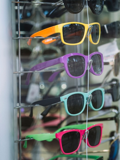 Photo gratuite lunettes de soleil colorées sur un support