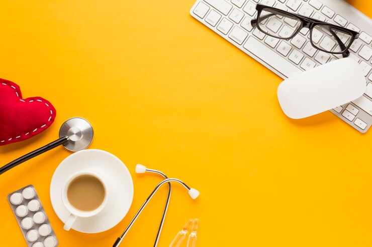 Photo gratuit lunettes de vue sur souris sans fil et clavier avec stéthoscope; cœur cousu; comprimé et tasse à café emballés sous blister contre une surface jaune