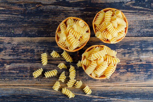 Macaroni en petits seaux sur fond de bois foncé. vue de dessus.