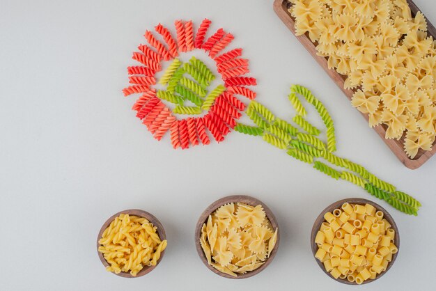 Macaronis crus colorés comme une fleur sur blanc