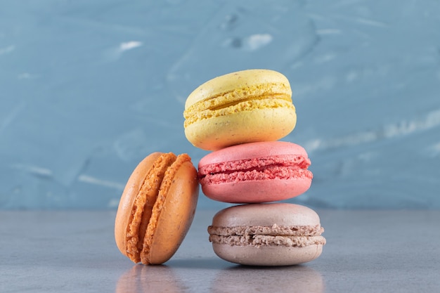 Macarons sucrés colorés crémeux placés sur une surface en marbre