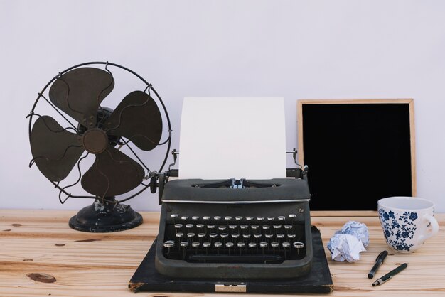 Machine à écrire près de tableau et ventilateur