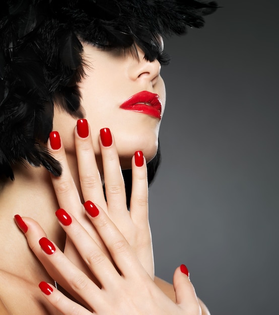 Photo gratuite macro photo de femme avec des ongles rouges fashion et des lèvres sensuelles