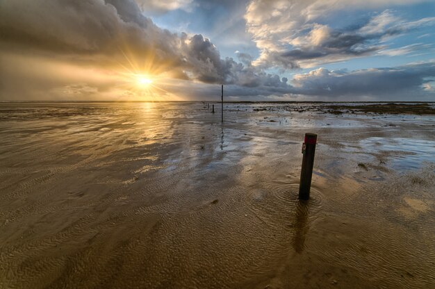 Magnifique coucher de soleil sur la plage créant le paysage parfait pour les promenades en soirée au bord