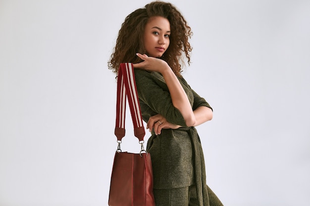 Magnifique portrait d'élégante femme noire aux cheveux bouclés en costume vert à la mode isolé sur blanc