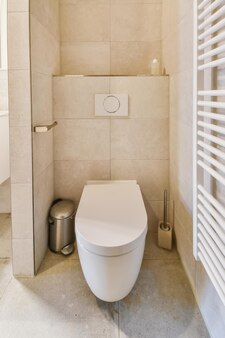 Magnifique salle de bain dans les tons beige avec un wc à côté du radiateur