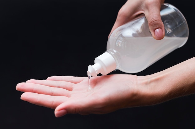 Main à l'aide d'un désinfectant pour les mains