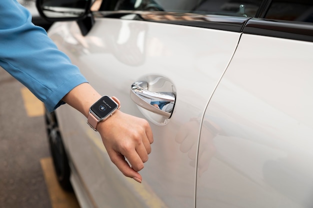 Photo gratuite main à l'aide de smartwatch pour déverrouiller la voiture en gros plan