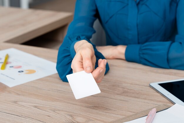 Main à angle élevé tenant une carte de visite