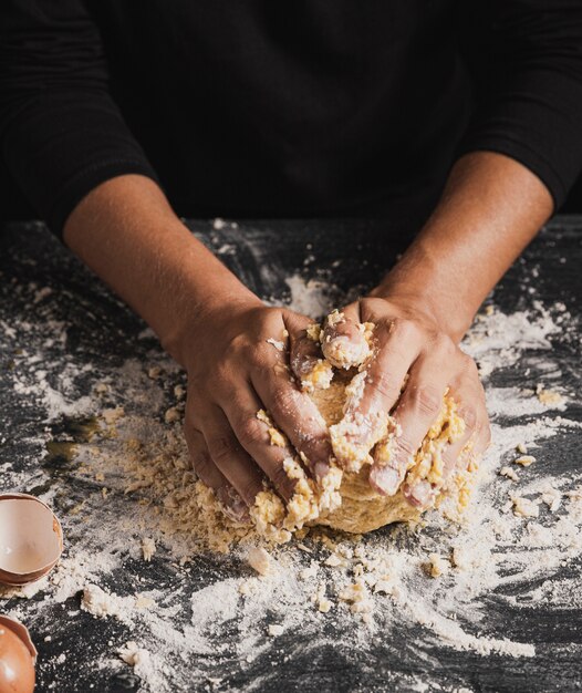 Main de boulanger à angle élevé mélangeant la pâte