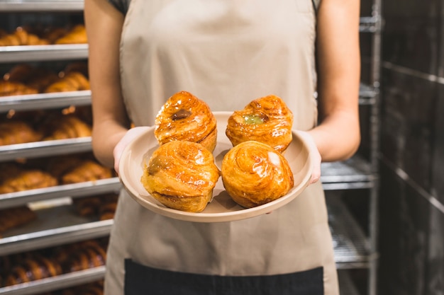 Photo gratuite main de boulanger femme tenant une pâte feuilletée sur une plaque