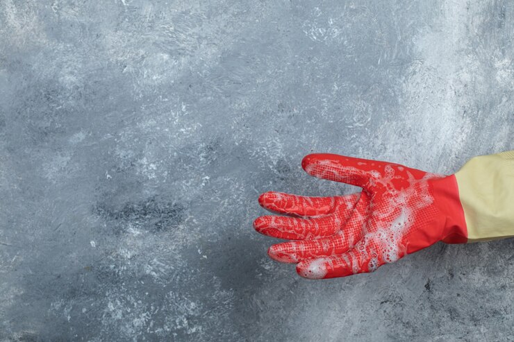 Photo gratuit main dans les gants de protection sur le marbre.