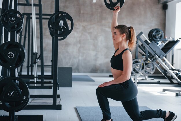 La main droite est levée. superbe femme blonde dans la salle de gym pendant son week-end