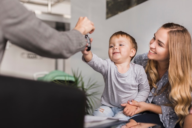 Main féminine donnant des clés de voiture à un bébé