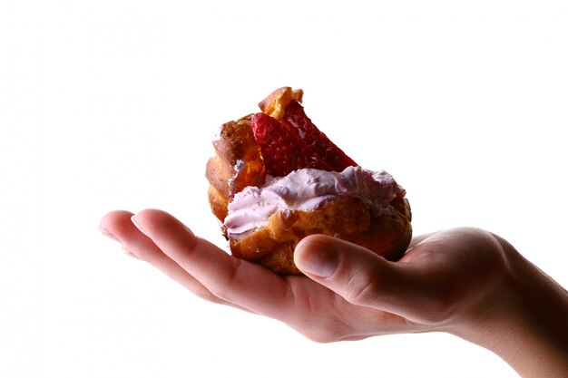 Main féminine avec gâteau aux fruits