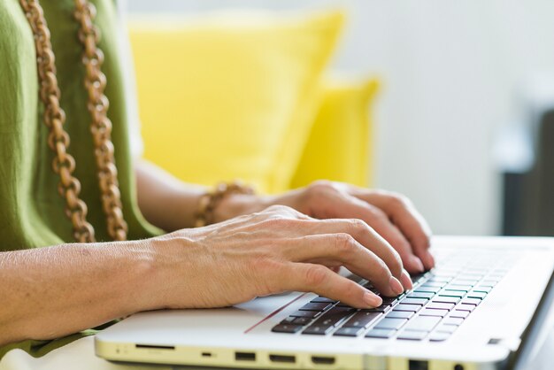 Une main de femme âgée sur un clavier d&#39;ordinateur portable