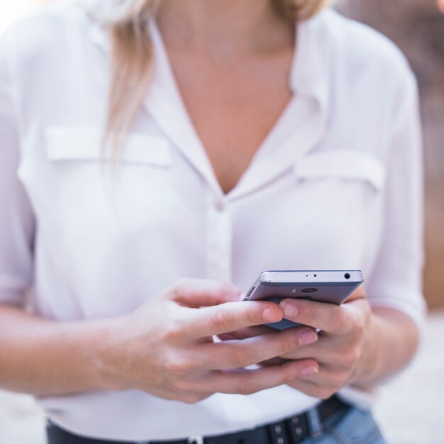 Main de femme à l&#39;aide de téléphone portable