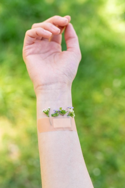 Main de femme avec fleurs et pansement