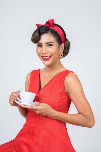 Main de femme de mode heureuse tenant une tasse de café