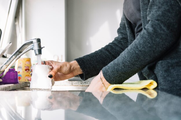 La main de la femme se lave la tasse dans l&#39;évier