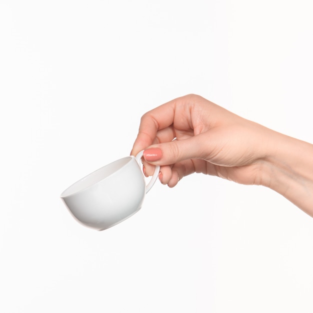 Main de femme avec tasse sur blanc