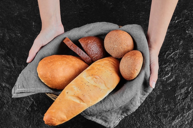 Main de femme tenant du pain fraîchement fait maison.